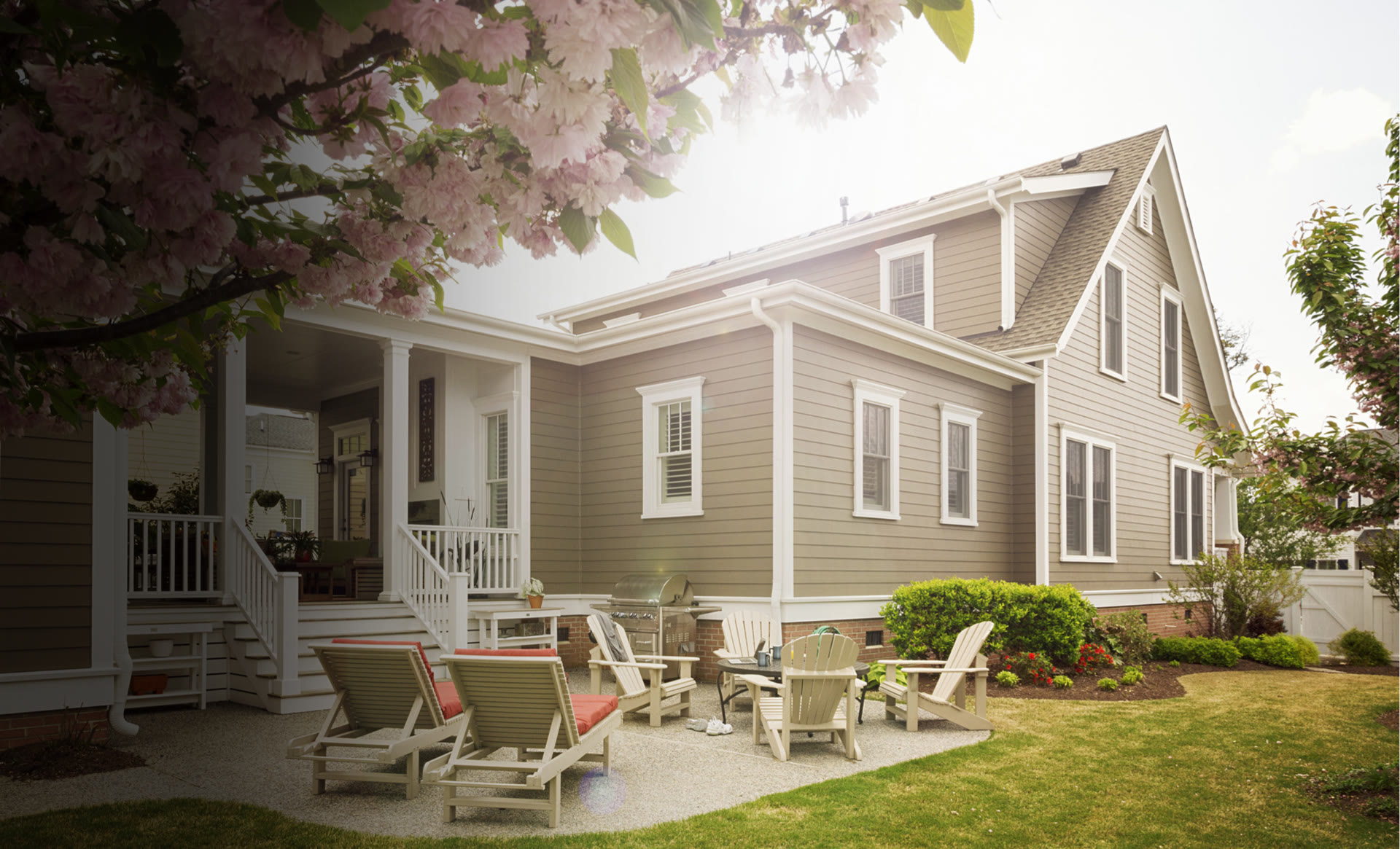 A recently finished Remod home with a patio, white trim, and blooming trees